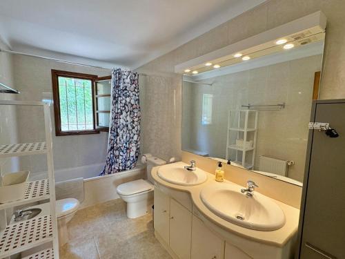 ein Badezimmer mit einem Waschbecken, einem WC und einem Spiegel in der Unterkunft Villa Puig Rosell in Calonge