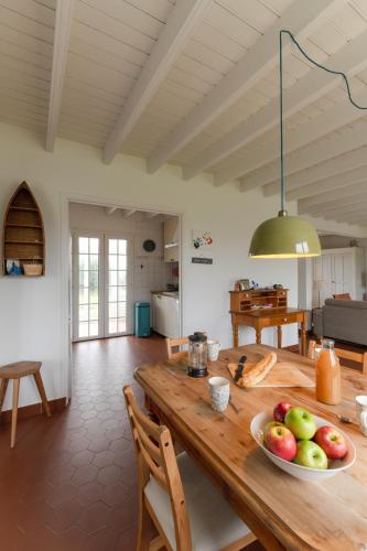 - une cuisine avec une table en bois et un bol de fruits dans l'établissement TY GWENN - Jolie Maison avec sauna proche mer, à Ploudalmézeau