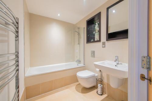 a bathroom with a sink and a toilet and a bath tub at Stunning City Centre Water VIews 2 Bed 2 Bath FREE PARKING in Leeds