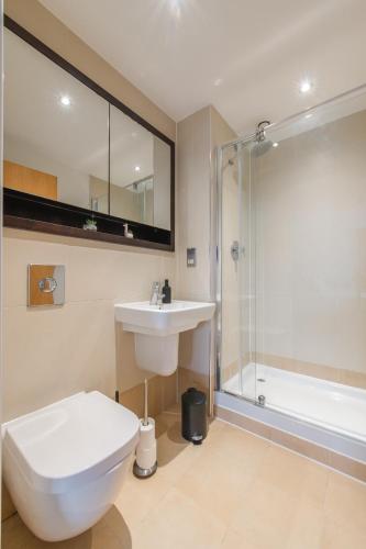 a bathroom with a toilet and a sink and a shower at Stunning City Centre Water VIews 2 Bed 2 Bath FREE PARKING in Leeds