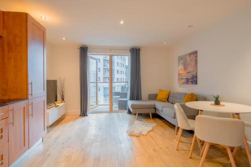 a living room with a couch and a table at Stunning City Centre Water VIews 2 Bed 2 Bath FREE PARKING in Leeds
