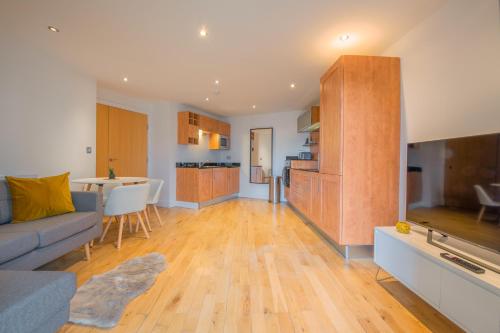 a living room with a couch and a kitchen at Stunning City Centre Water VIews 2 Bed 2 Bath FREE PARKING in Leeds