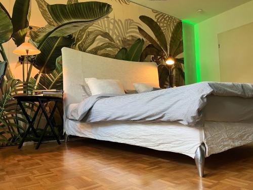 a bedroom with a bed with white sheets and plants at Designerwohnung nahe Stuttgart Messe und Flughafen in Filderstadt