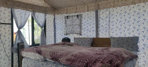 una camera da letto con un letto con carta da parati blu e bianca di Hinwali Kanthi River Side Camp and Cottage a Harsil