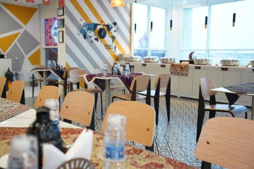 a restaurant with tables and chairs and a counter at Resivation Hotel in Dubai