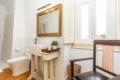 uma casa de banho com um lavatório, um WC e um espelho. em Casa de Santo António 