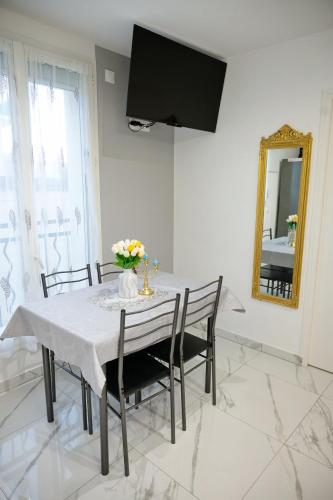 a dining room with a table with chairs and a mirror at Appartement Bronze 2 pièces de 44 m2 in Noisy-le-Sec