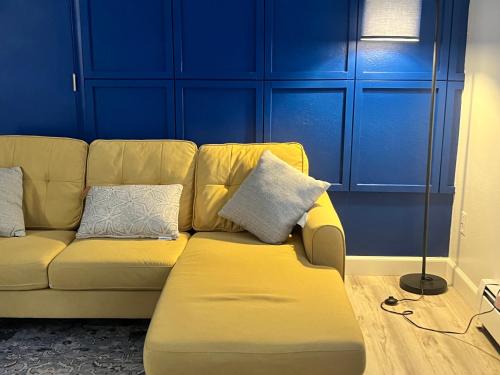 a yellow couch in a room with a blue wall at Beautiful downtown Anchorage 4 in Anchorage