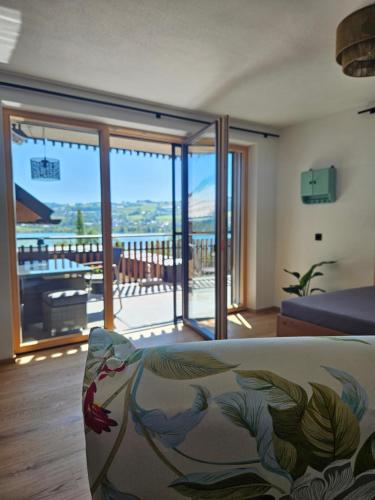 a living room with a couch and a view of a balcony at Serner am See in Zell am Moos