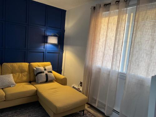 a yellow couch in a living room with a window at Beautiful downtown Anchorage 4 in Anchorage