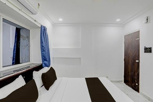 um quarto com uma cama branca e uma janela em OYO 82287 Hotel Dream 1 Inn em Rāipur
