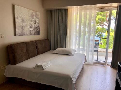 a bedroom with a large bed with a large window at Apartman Bella in Makarska