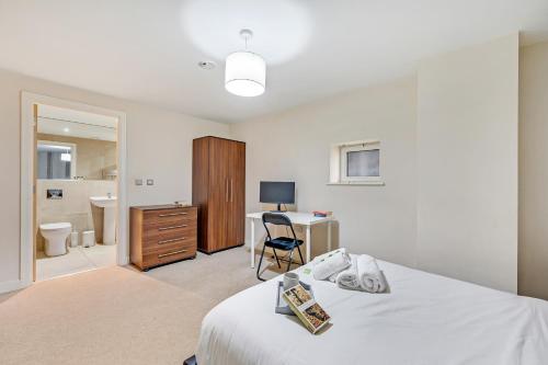 a bedroom with a bed and a desk with a computer at The Railway Pass The Keys Modern 2-Bed Apartment in Central Altrincham in Altrincham