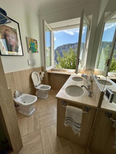 bagno con lavandino, servizi igienici e finestra di Roof Top Belvedere a Capri