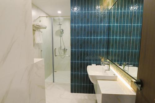 La salle de bains est pourvue d'un lavabo et d'une douche. dans l'établissement Glamour Boutique, à Phan Rang