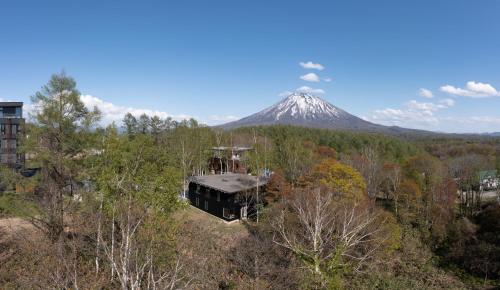 a building in front of a snow covered mountain at Yuki Sugi at Intuition in Kutchan