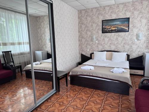a hotel room with two beds and a mirror at Motel Xameleon in Voznesensk