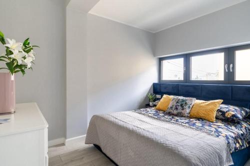 a bedroom with a blue bed with yellow pillows at Mi Bella 1 in Gdynia