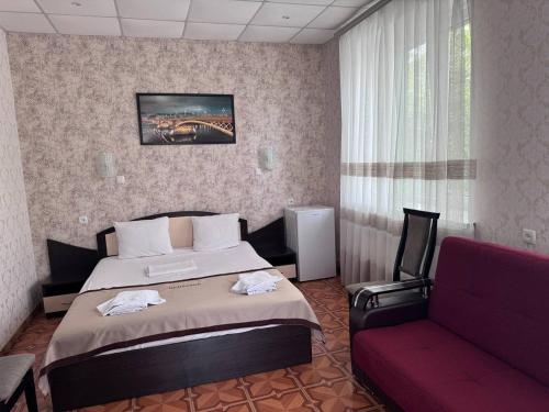 Habitación de hotel con cama y sofá rojo en Motel Xameleon en Voznesensk