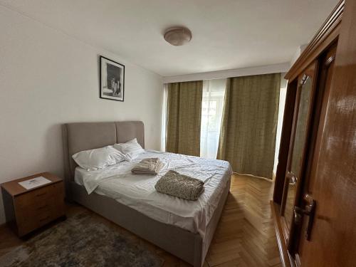 1 dormitorio con 1 cama con mesita de noche y ventana en Decebal apartment overlooking the boulevard, en Bucarest