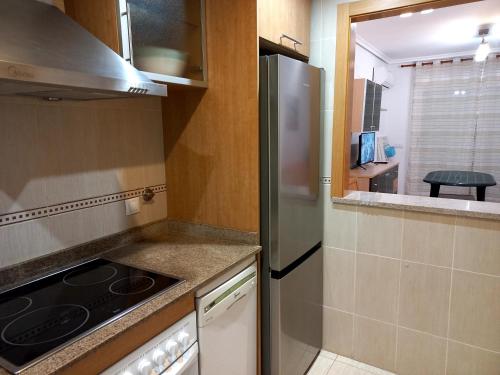 eine kleine Küche mit einem Kühlschrank und einem Herd in der Unterkunft Costa Azahar II Nº 1041 in Oropesa del Mar