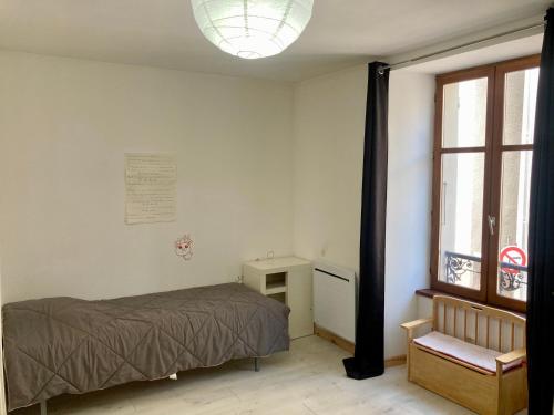 une chambre avec un lit, une fenêtre et une chaise dans l'établissement Maison de ville idéalement située, au Bourg-dʼOisans
