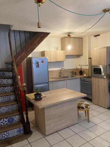 une cuisine avec un escalier menant à une cuisine équipée d'un réfrigérateur dans l'établissement Maison de ville idéalement située, au Bourg-dʼOisans