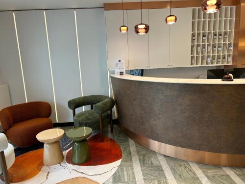 a lobby with a bar with two chairs and tables at Urban Style L'Etape in Saint-Flour