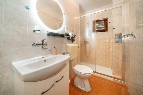y baño con lavabo, aseo y espejo. en Apartment & Double Room Stanka, en Baška