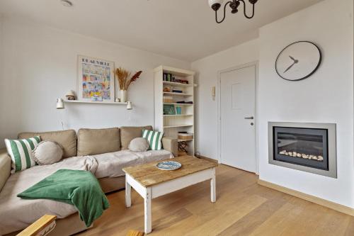 a living room with a couch and a fireplace at Rempaulchrist 0202 P in Sint-Idesbald