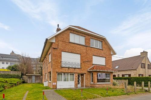 a brick house with white windows and a roof at Rempaulchrist 0202 P in Sint-Idesbald