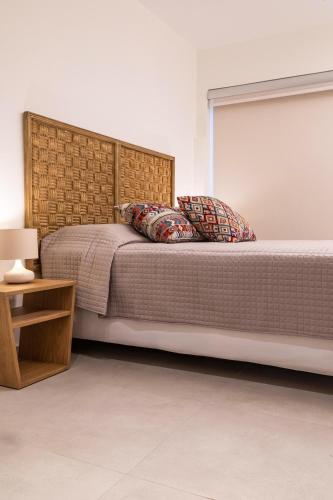 a bedroom with a large bed with a wooden headboard at Arancia Elegant Rooms and Suites in Tolo