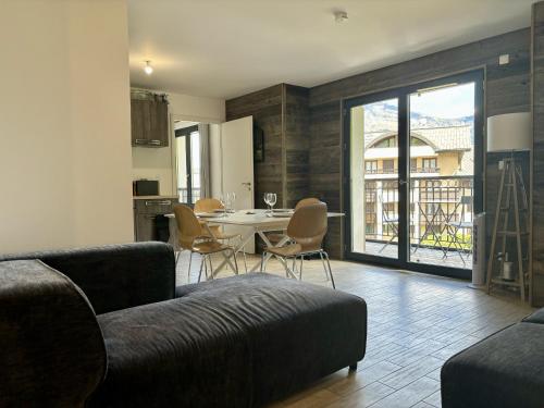 un salon avec un canapé et une table avec des chaises dans l'établissement Le Bettex - Lumineux - Vue montagne, à Saint-Gervais-les-Bains