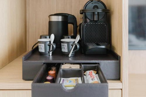 a black box with coffee cups and a coffee maker at New Elegance Suites Guesthouse in Oristano