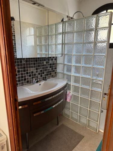 une salle de bain avec un lavabo et un miroir dans l'établissement Chemin du Bord de mer, à La Seyne-sur-Mer