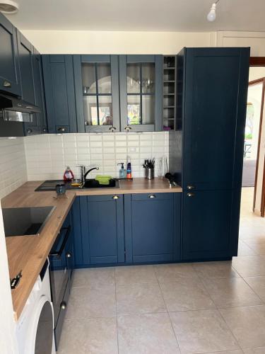 une cuisine avec des armoires bleues et un comptoir dans l'établissement Chemin du Bord de mer, à La Seyne-sur-Mer