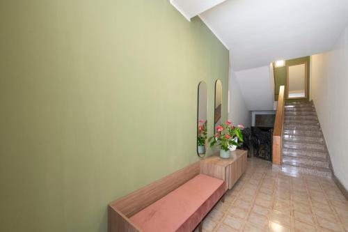 a room with a bench and a staircase with flowers at B&B D'Amely in Melendugno