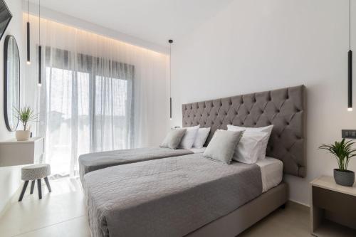 a bedroom with a large bed with a large window at Sun White Villas in Laganas