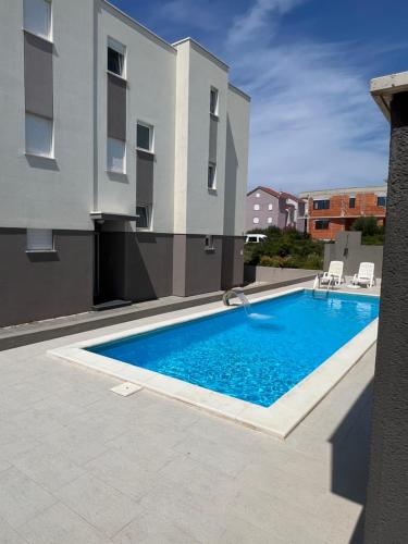 une piscine en face d'un bâtiment dans l'établissement The Palms Luxury Pool Aparthotel, à Novalja