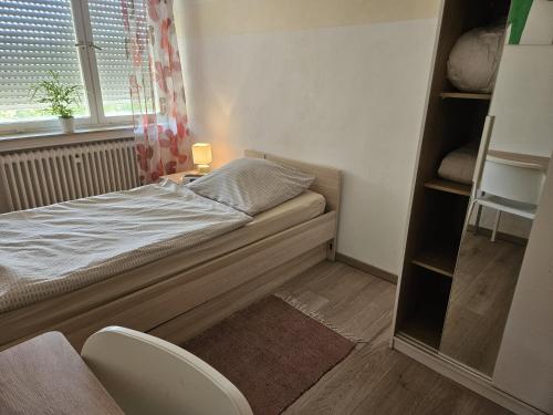 a small bedroom with a bed and a window at Die Wohnung Stein in Bretzfeld