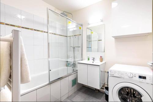 une salle de bain blanche avec une machine à laver à l'intérieur dans l'établissement Jolie 2 pièces à Aubervilliers, à Aubervilliers