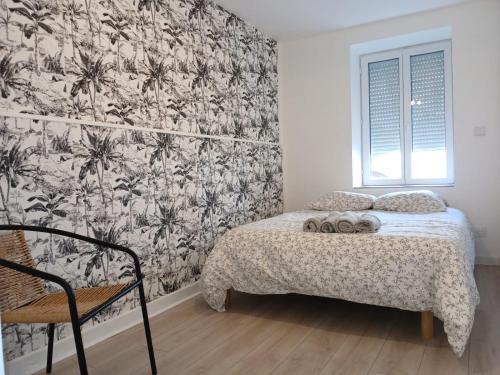 a bedroom with a bed with a black and white wallpaper at L exotique in Marlieux