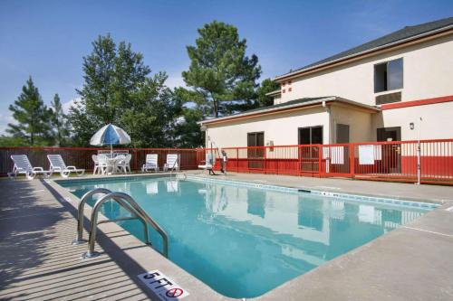 una piscina con terraza y un edificio en Days Inn by Wyndham Mauldin/Greenville, en Greenville