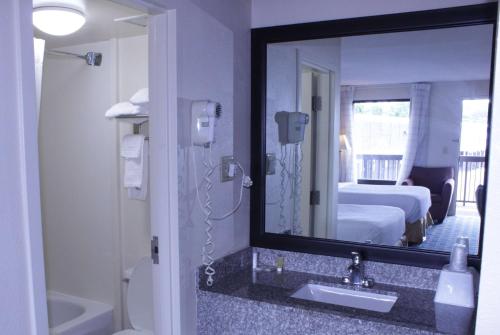baño con lavabo y espejo grande en Days Inn by Wyndham Salem, en Salem