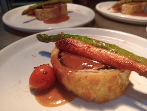 a plate of food with a hot dog and asparagus at Restaurante & Hotel Rural El Mirador de Trevejo,ideal para parejas in Villamiel