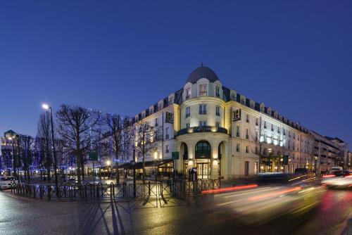 a large building on a city street at night at L'Elysée Val d'Europe in Serris