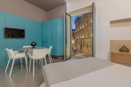 a bedroom with a bed and a table and chairs at Fiveplace Design Suites & Apartments in Trapani