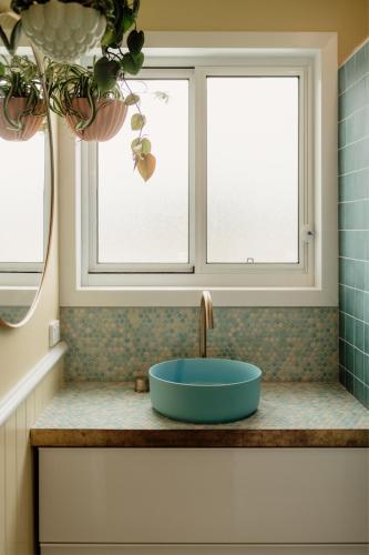 a bathroom with a sink and two windows at Sunny Beach Box in Sunderland Bay