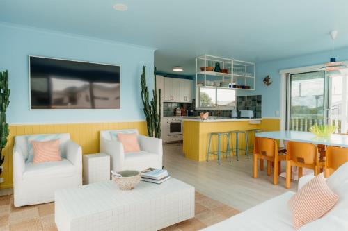 a living room and kitchen with a table and chairs at Sunny Beach Box in Sunderland Bay