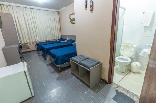 ein Schlafzimmer mit einem Bett, einem WC und einer Dusche in der Unterkunft Alfa Hotel Vespasiano in Vespasiano